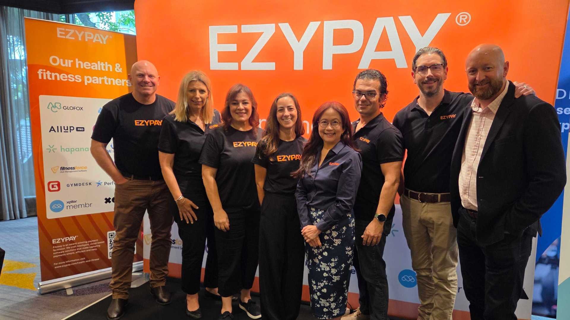 Ezypay team standing in front of company banner