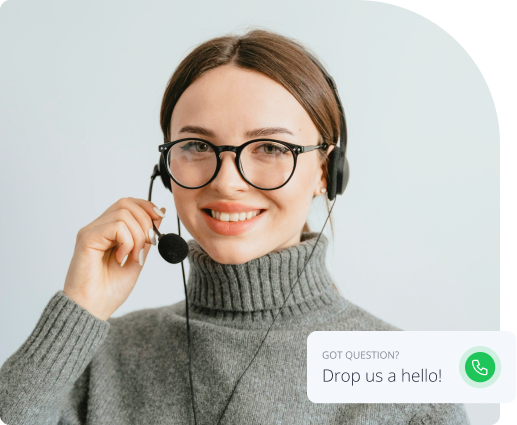 A smiling woman wearing glasses and a headset, with a hand on her microphone, against a light background. A text overlay says, 