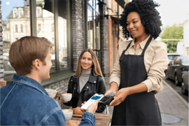 A man paying coffee with his ewallet to the cafe waitress