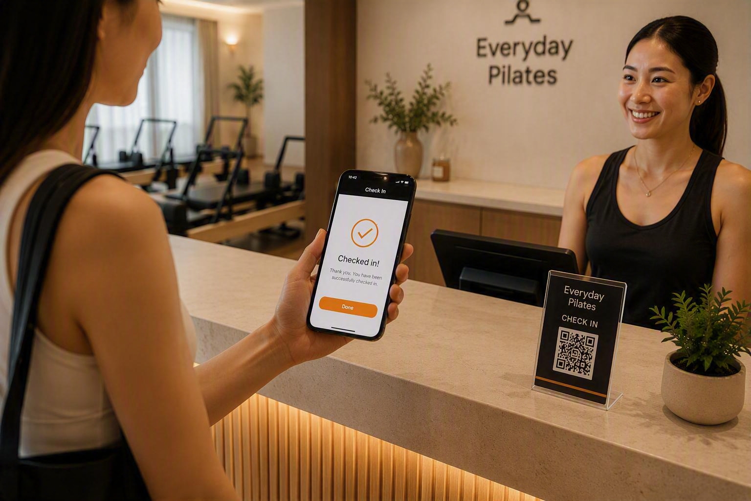 Mobile self check-in at Everyday Pilates using a smartphone and QR code stand at the pilates studio reception counter.