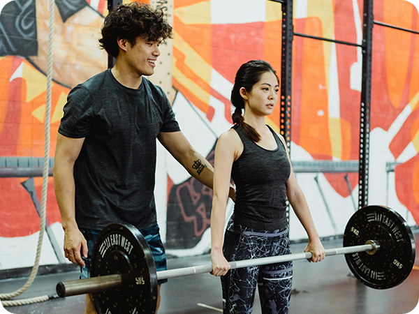 Man couching a lady in the gym
