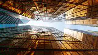 An image of a cities skyline, looking up from the ground floor. The buildings are Ezypay orange in colour. 