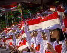 Crowd of young Indonesians waving the Indonesian flag