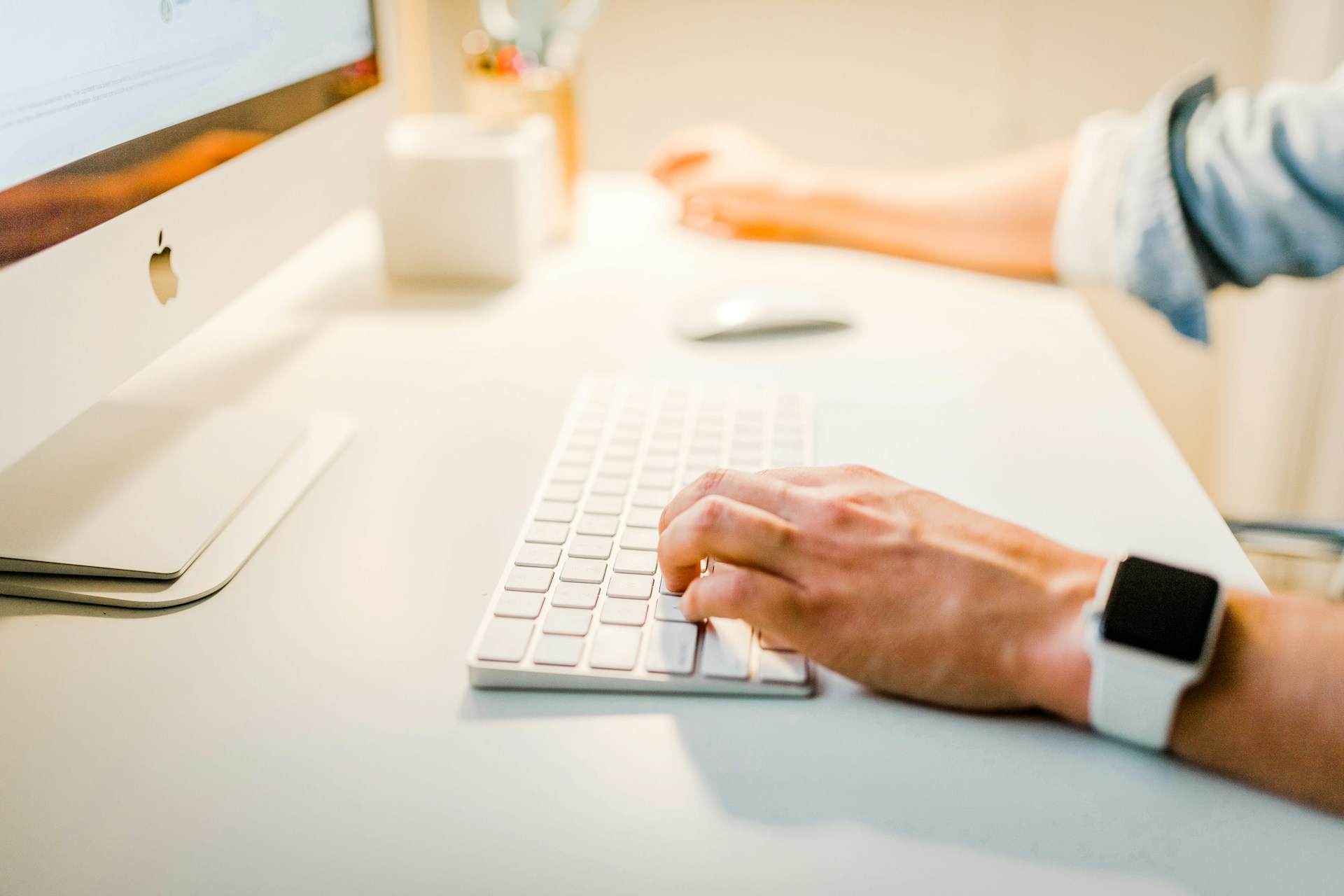 A person types on a keyboard. Only their hands are in frame.