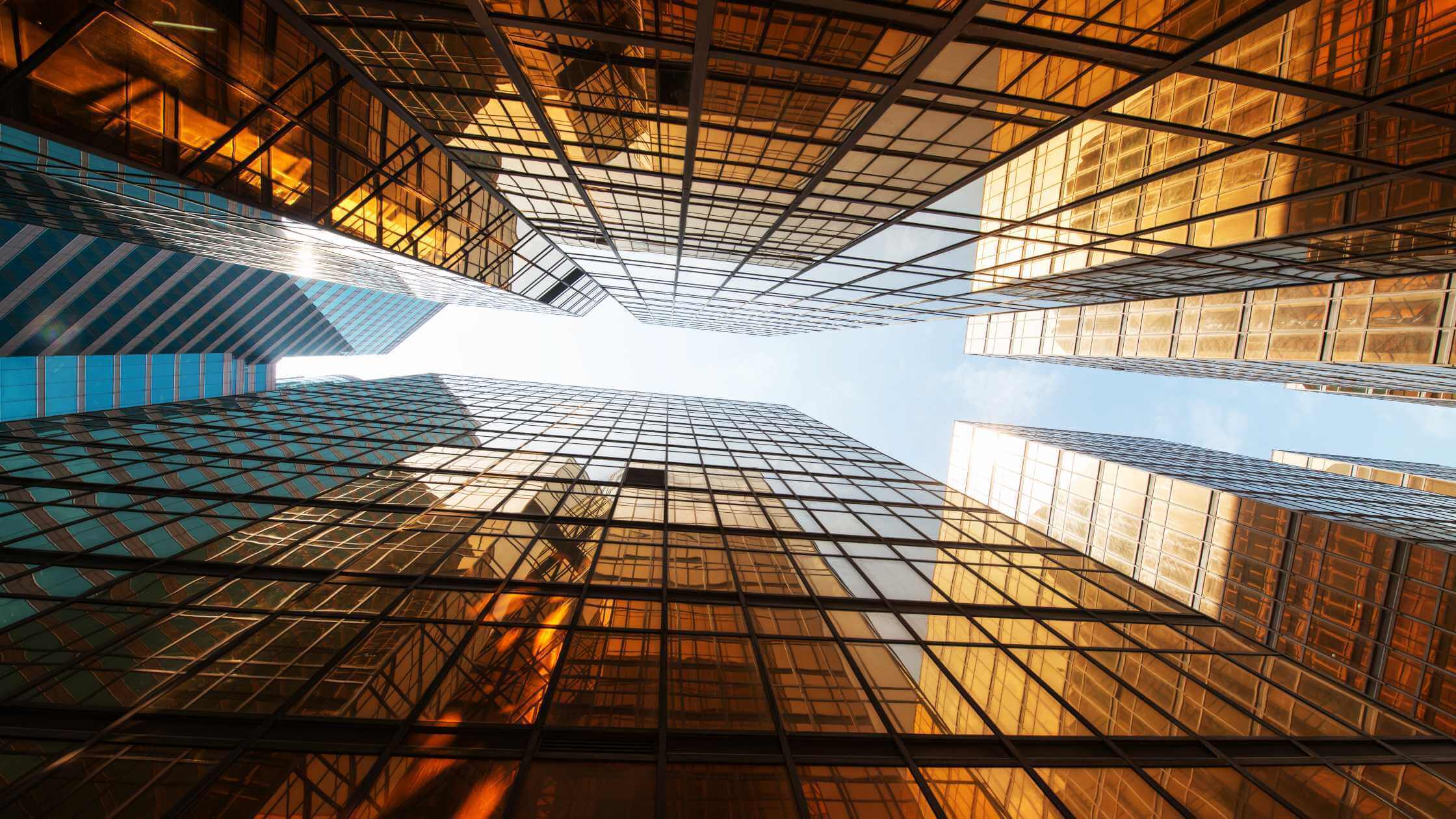 An image of a cities skyline, looking up from the ground floor. The buildings are Ezypay orange in colour. 