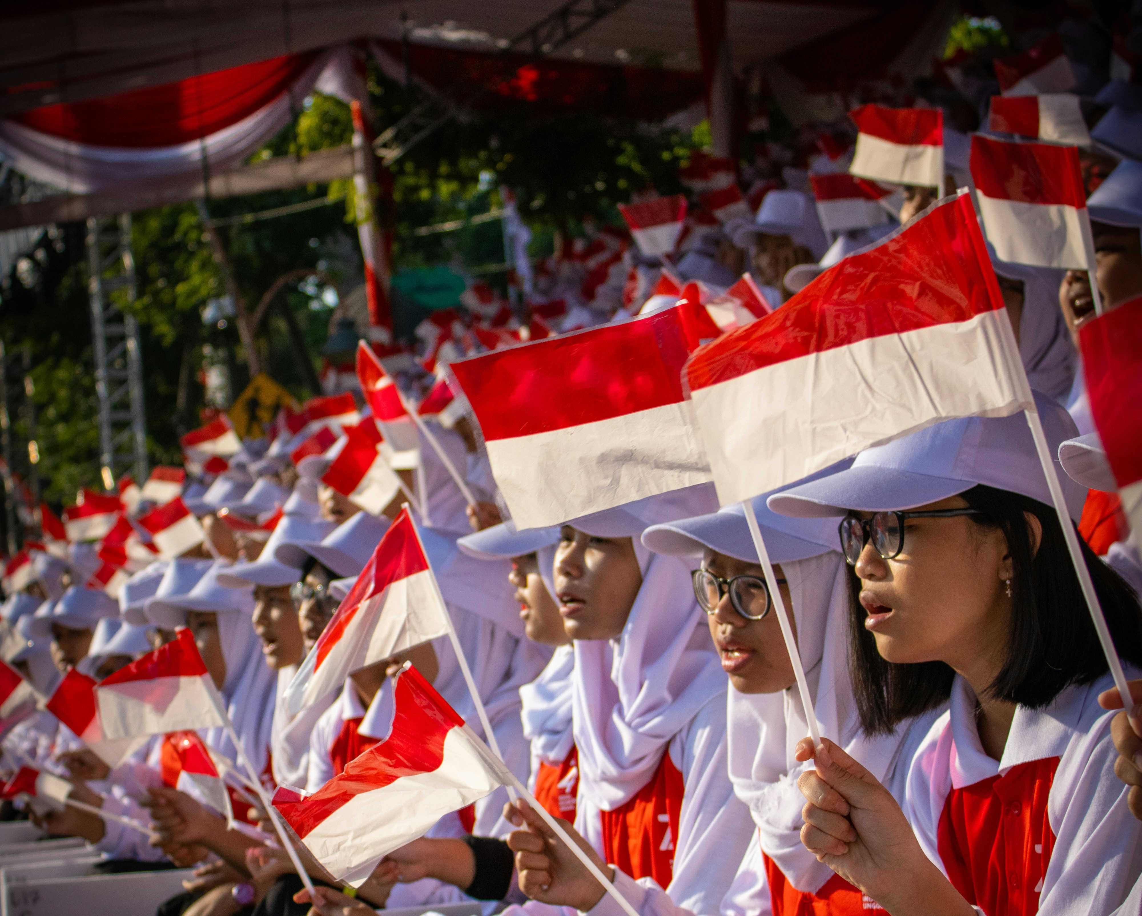 Crowd of young Indonesians waving the Indonesian flag